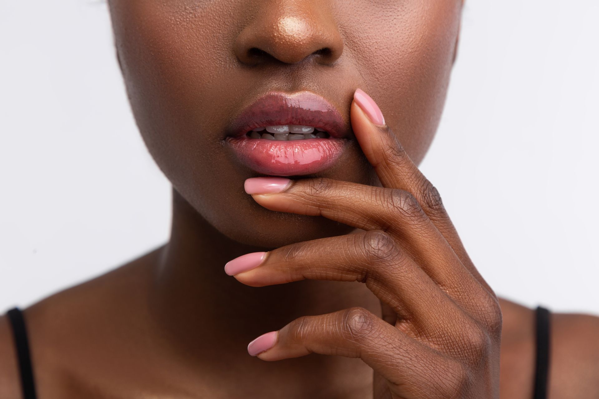 A close up of a woman 's face with her hand on her lips.