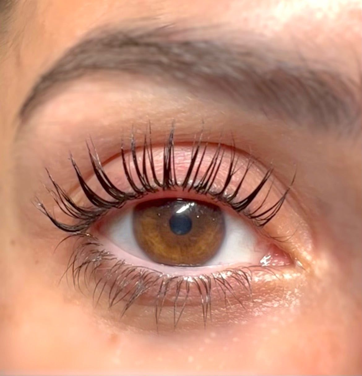 A close up of a woman 's eye with long eyelashes.