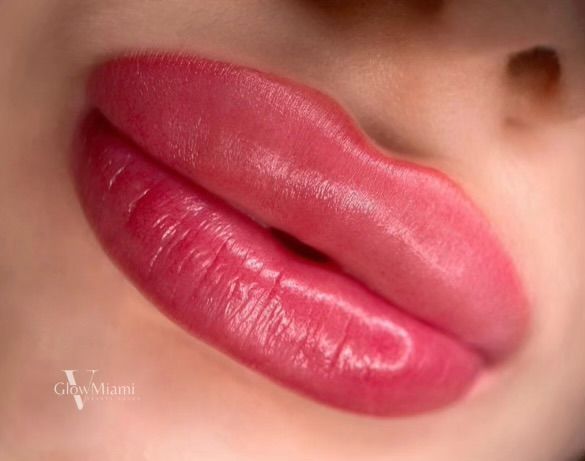 A close up of a woman 's lips with pink lipstick.