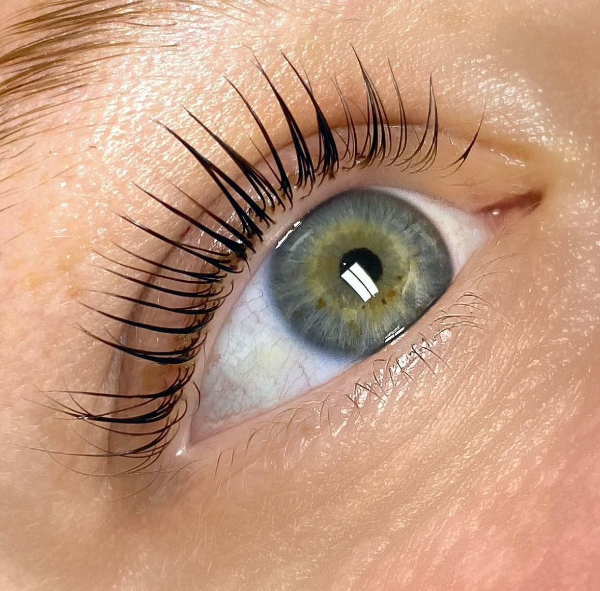 A close up of a woman 's eye with long eyelashes.