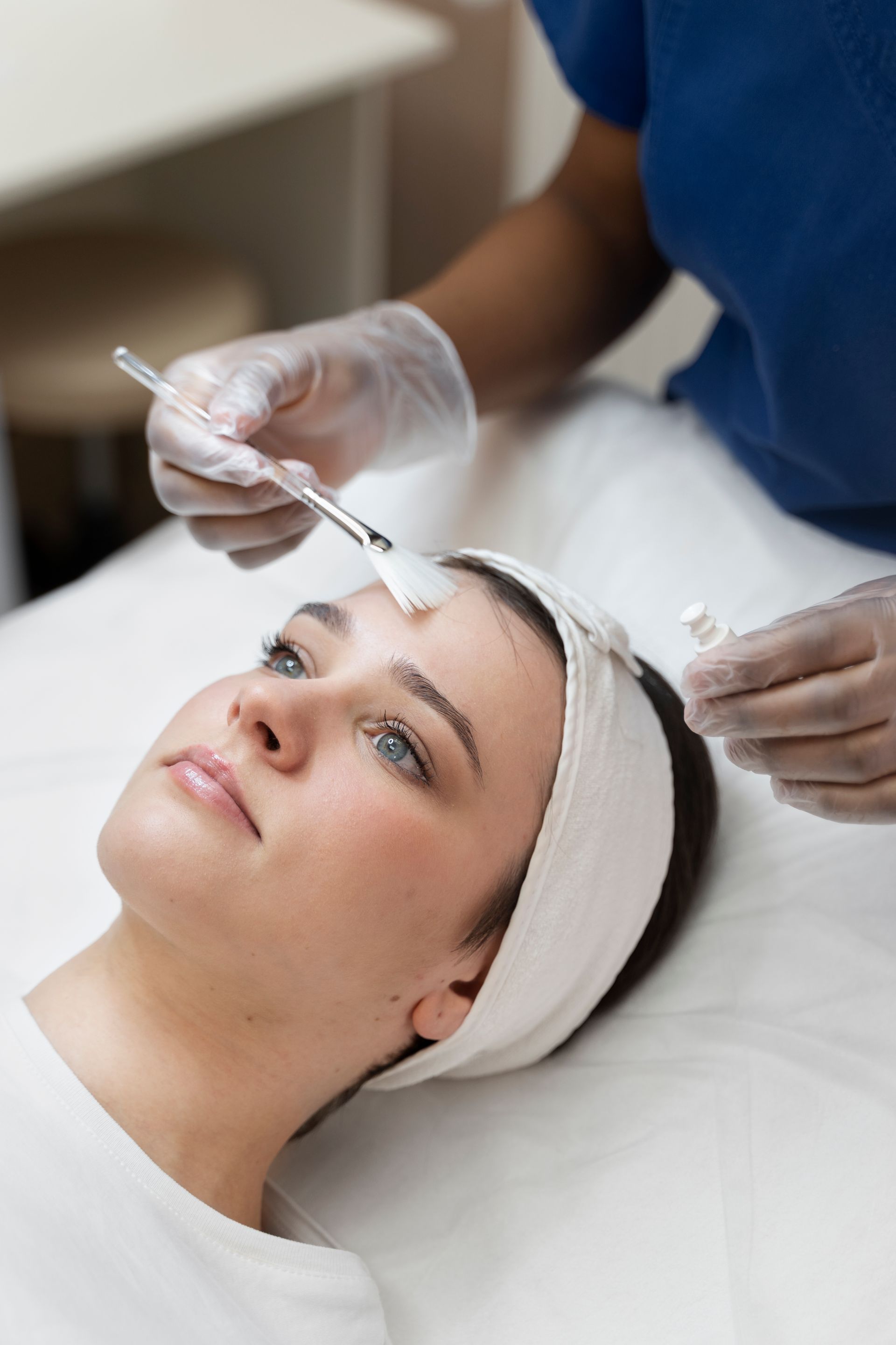 A woman is getting a facial treatment at a beauty salon.