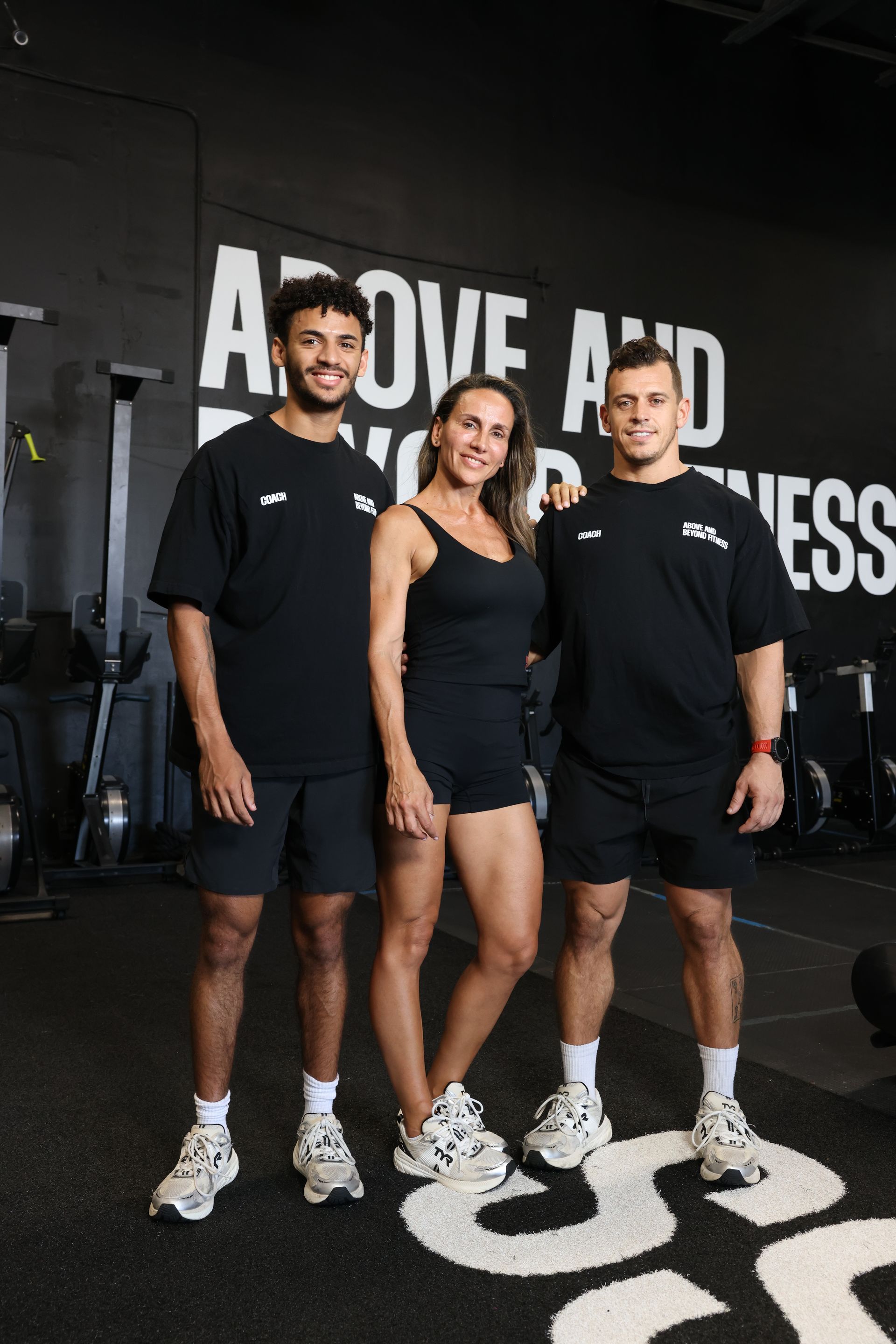 A man and a woman are standing next to a wooden box in a gym.