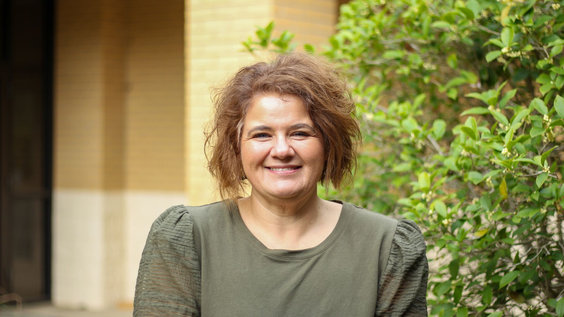 A woman is smiling for the camera in a church.