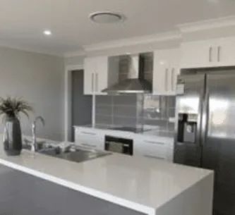 A kitchen with white cabinets , stainless steel appliances , a sink , and a refrigerator.