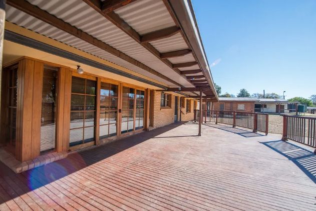 A large brick building with a wooden deck in front of it.