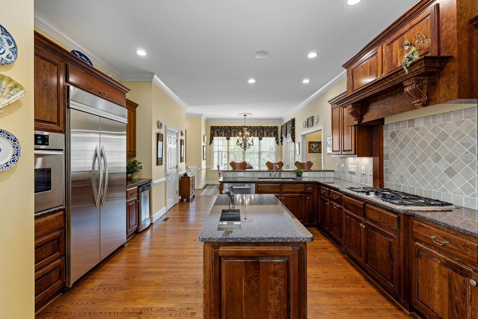 A large kitchen with stainless steel appliances and wooden cabinets.