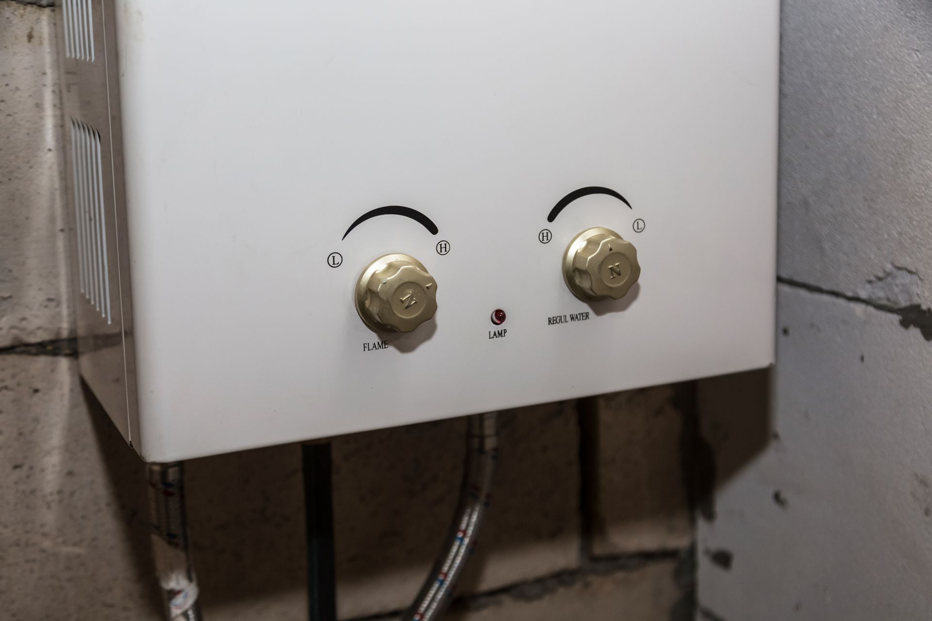 a white gas water heater is hanging on a brick wall .