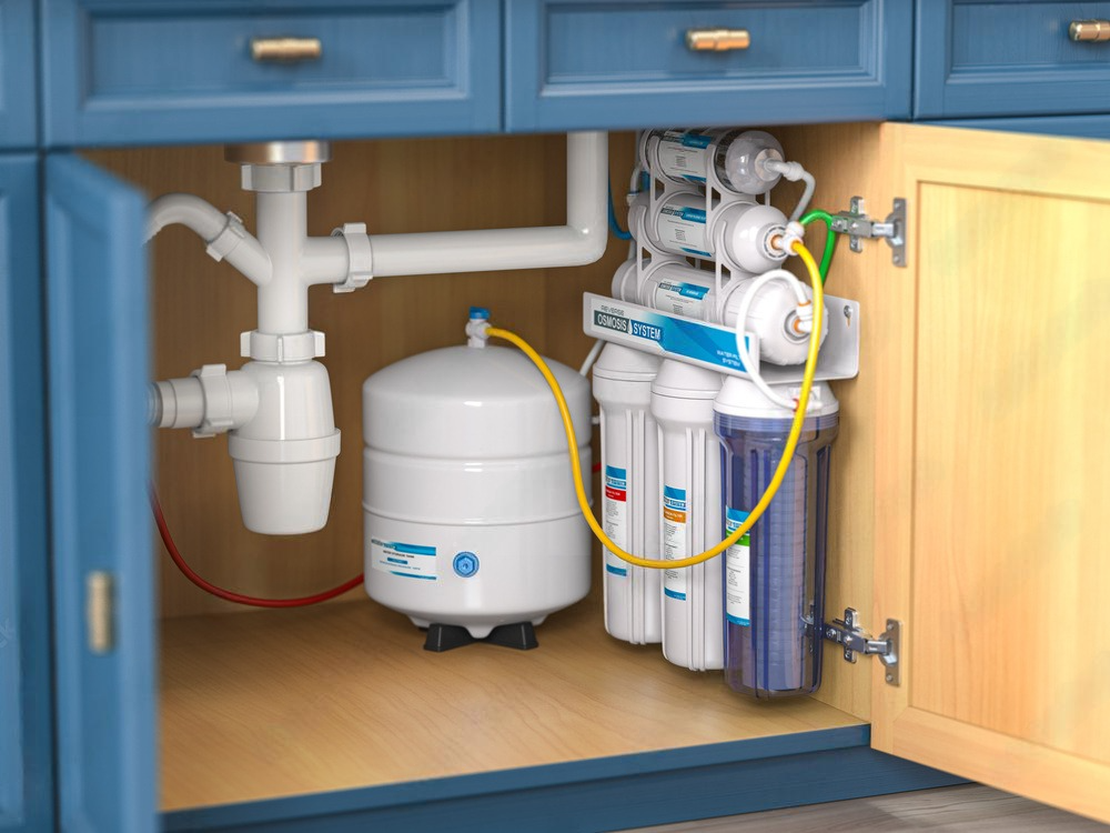 a water filter is installed under a sink in a kitchen cabinet .