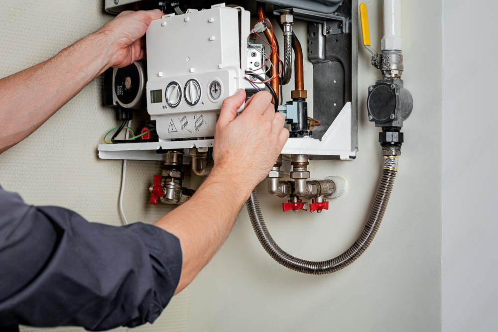 a man is fixing a boiler in a room .