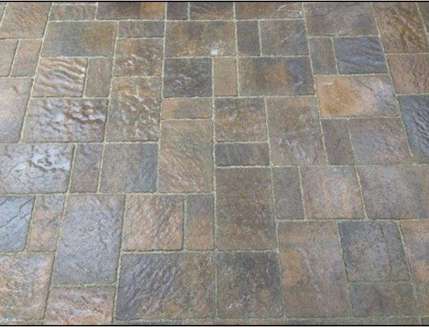 Brown and gray stone patio pavers in a random pattern.
