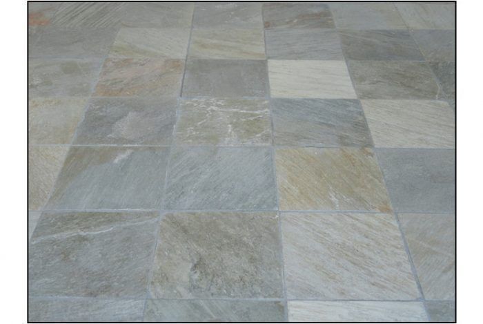 Square slate tiles in varying shades of gray and beige arranged in a grid pattern.