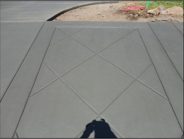 Gray concrete driveway with a diamond pattern, freshly poured.