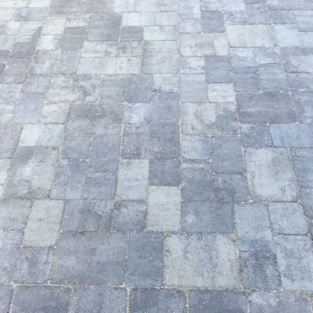 Gray and blue-toned stone pavers in a random pattern, covering an outdoor surface.