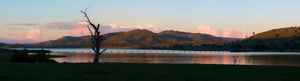 A Lake With Mountains In The Background And A Tree In The Foreground — Romy Sidhu Ray White Weir Views In Weir Views, VIC