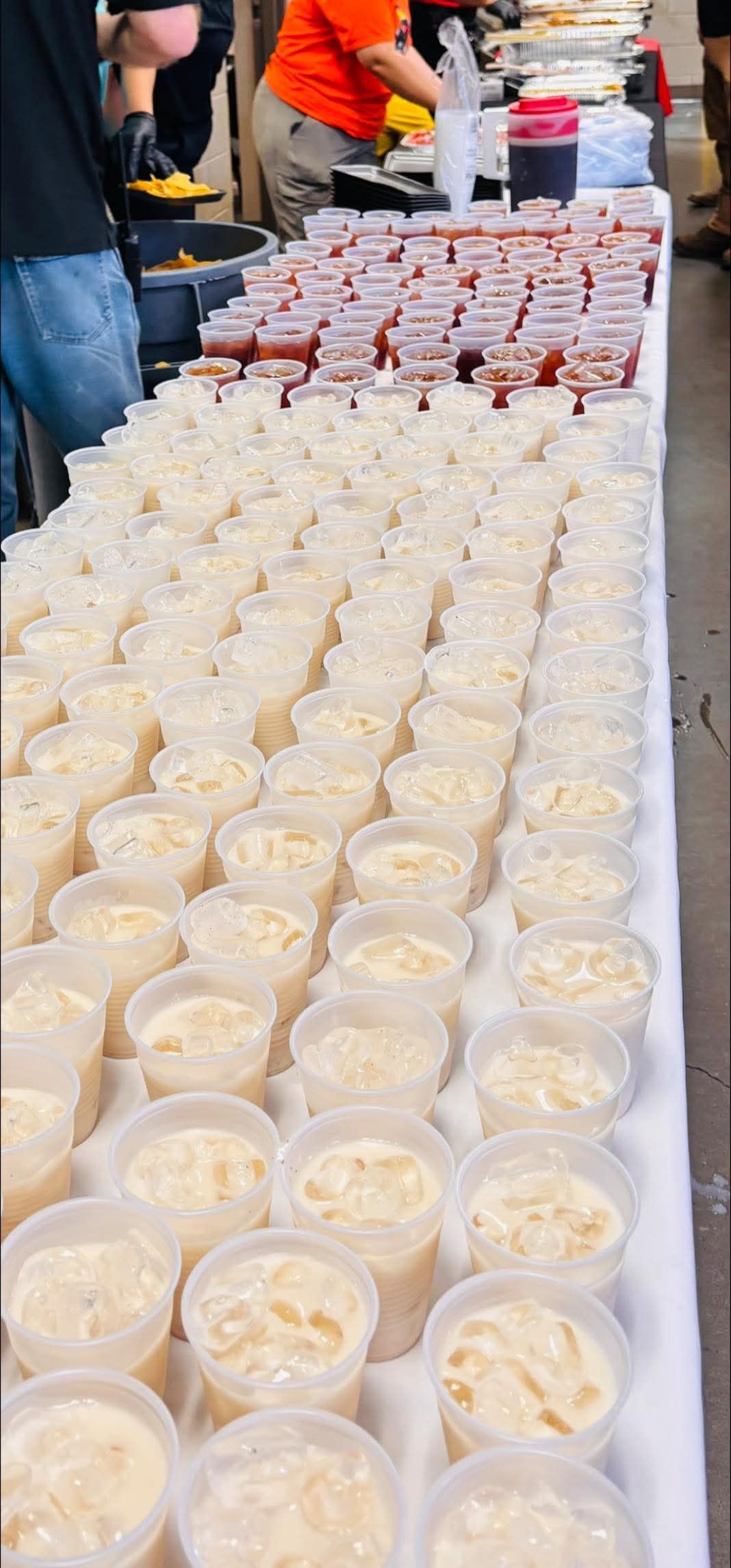 Three birria tacos with dipping sauce and lime wedges on a yellow plate.