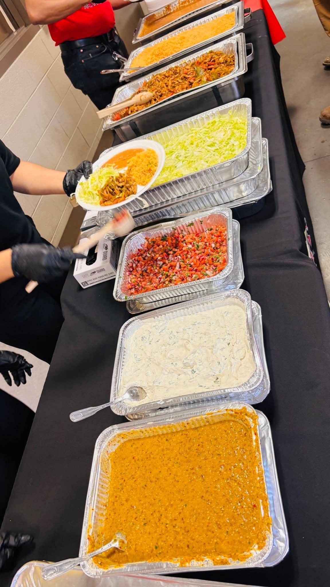 Quesadilla, cut into wedges, on a plate with guacamole, salsa, shredded cabbage, and sour cream.