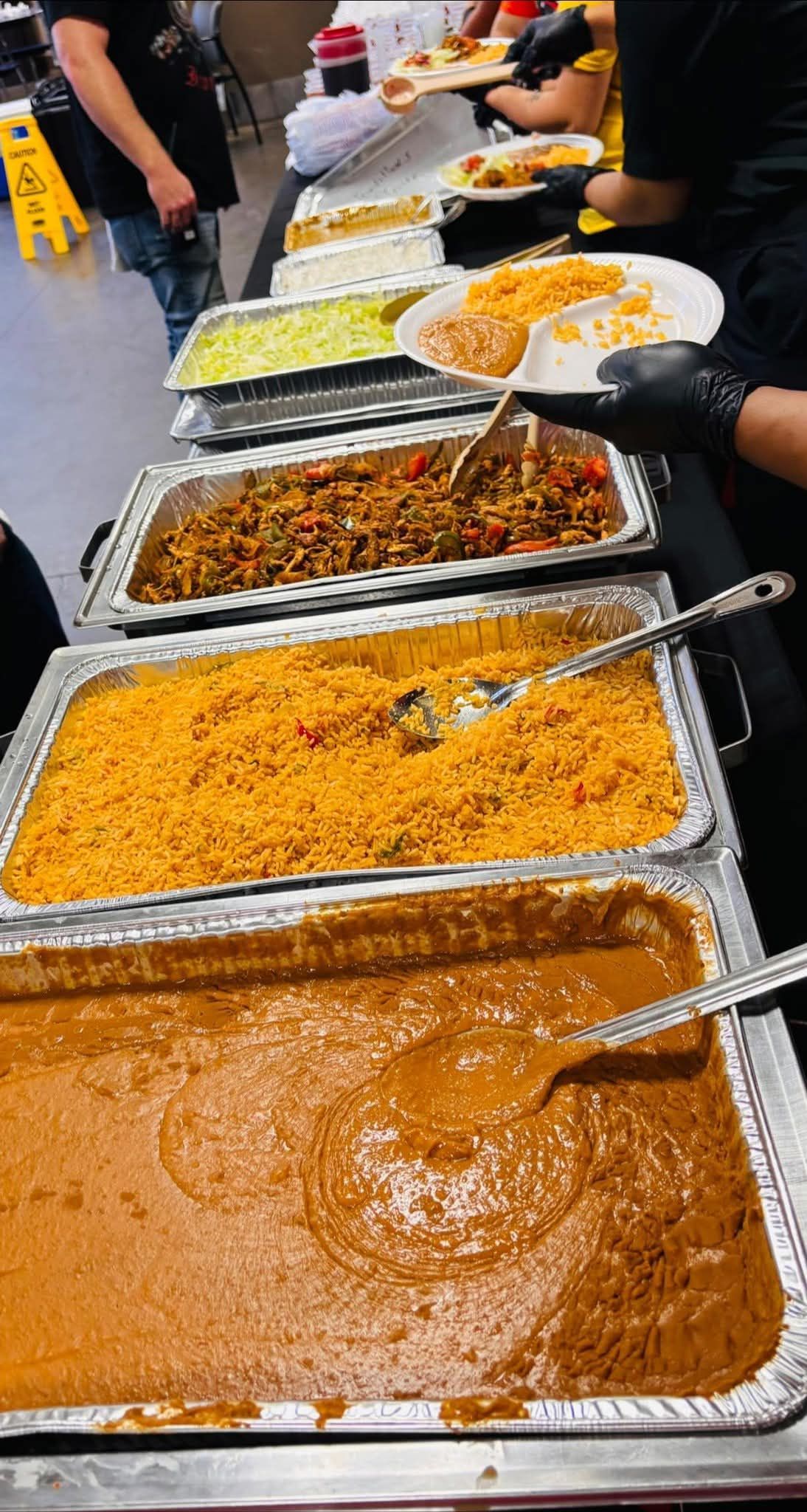 Plate of Mexican food: enchilada, rice, and refried beans.