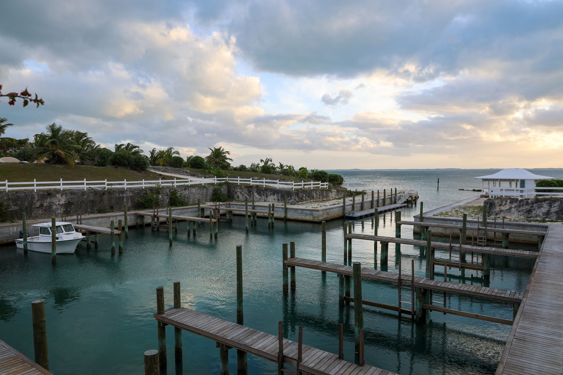 Marina with wooden docks, calm water, and sunset bar.