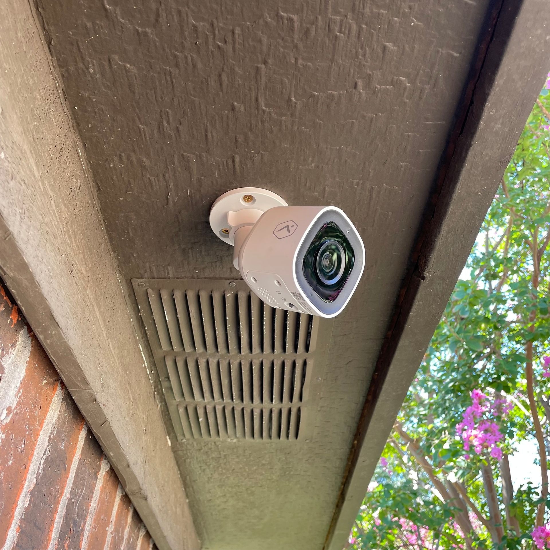 A security camera is mounted on the side of a building.