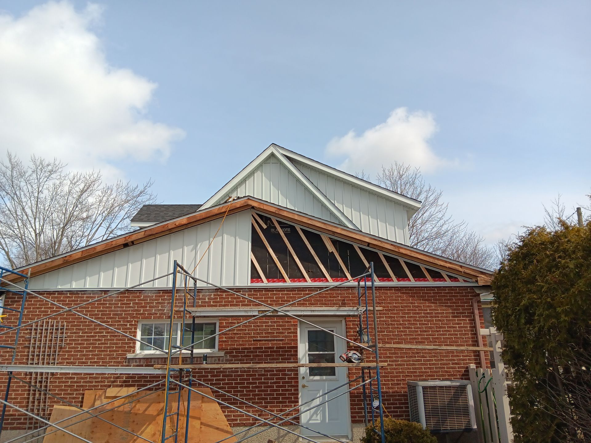 Une maison en brique avec un toit blanc est en cours de rénovation