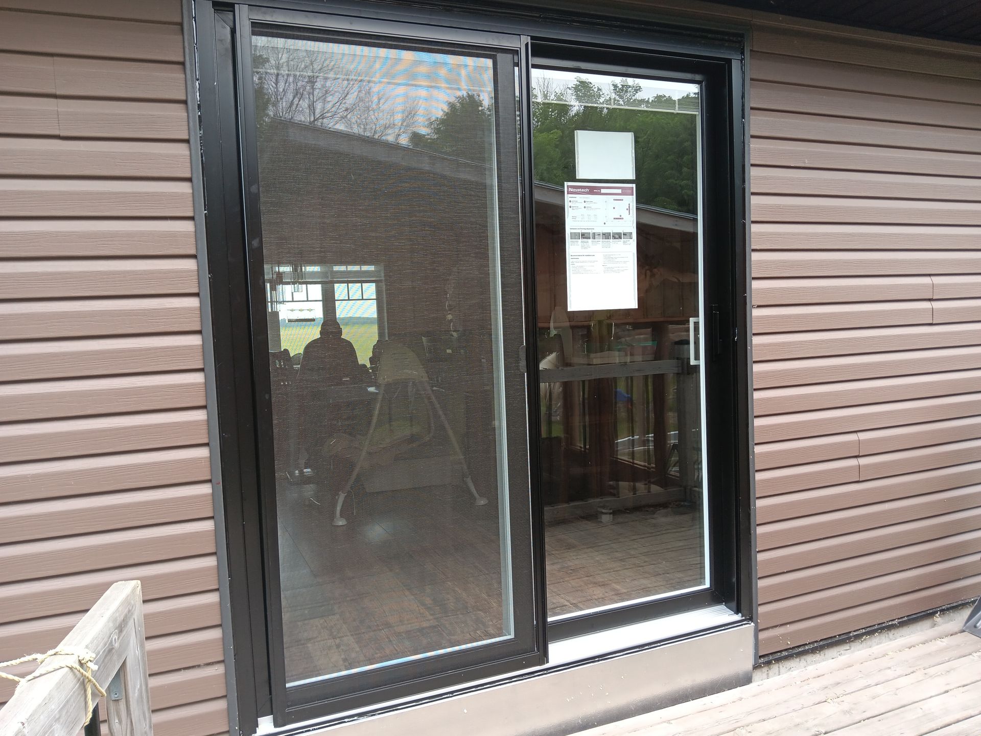 Une maison marron avec une porte coulissante en verre