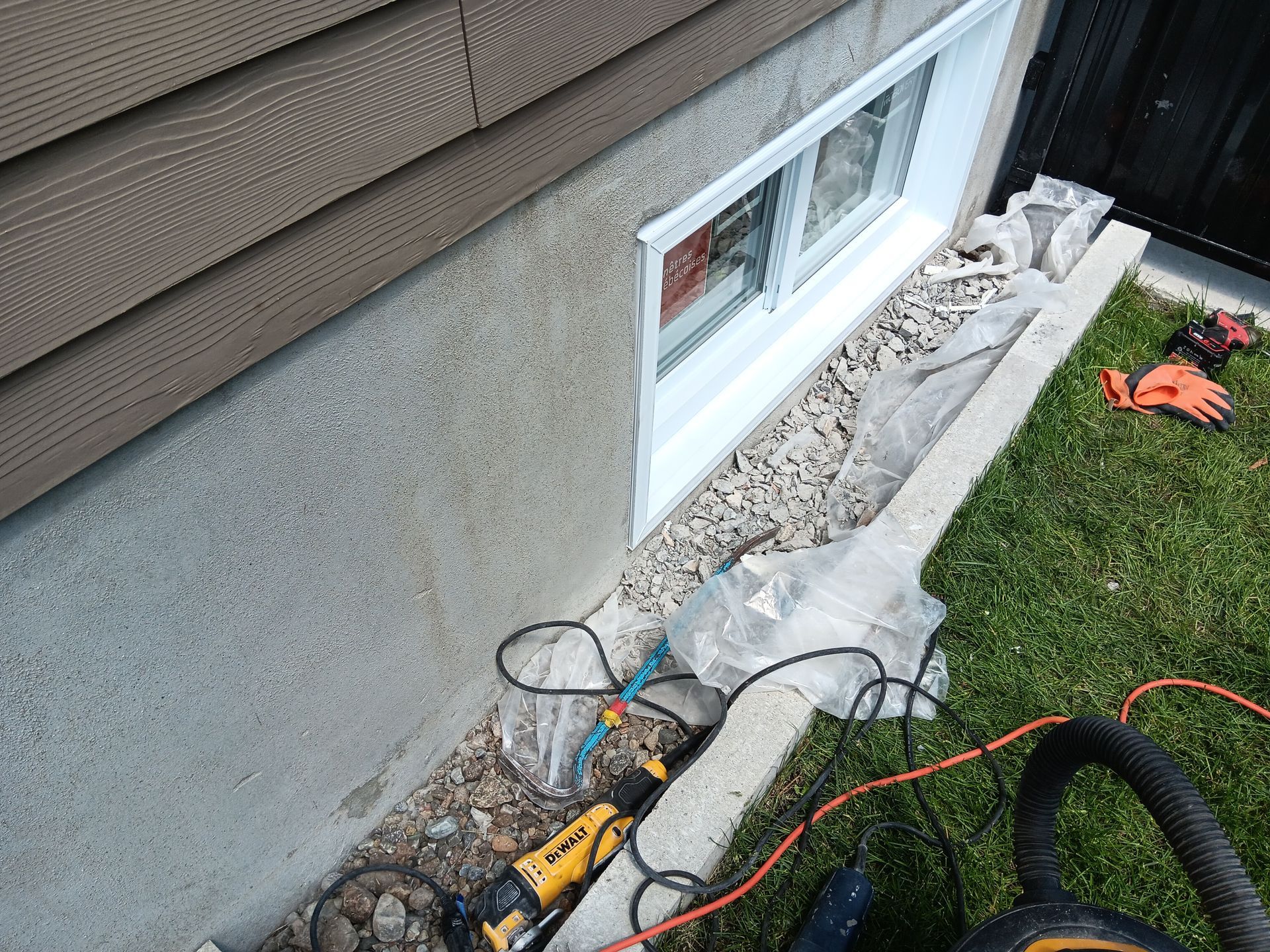 Une fenêtre est en cours d'installation sur le côté d'une maison.