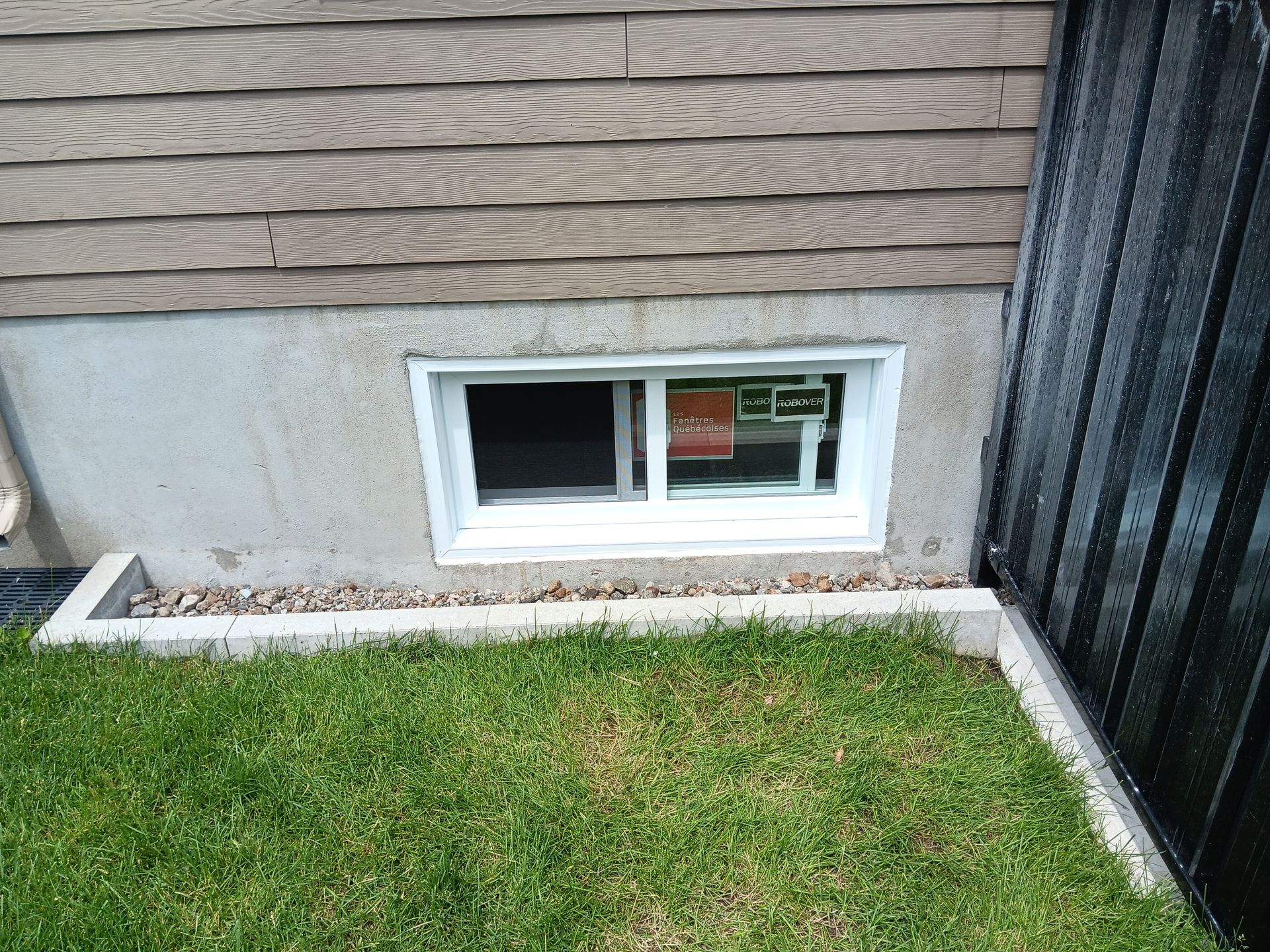 Il y a une fenêtre au sous-sol d'une maison.