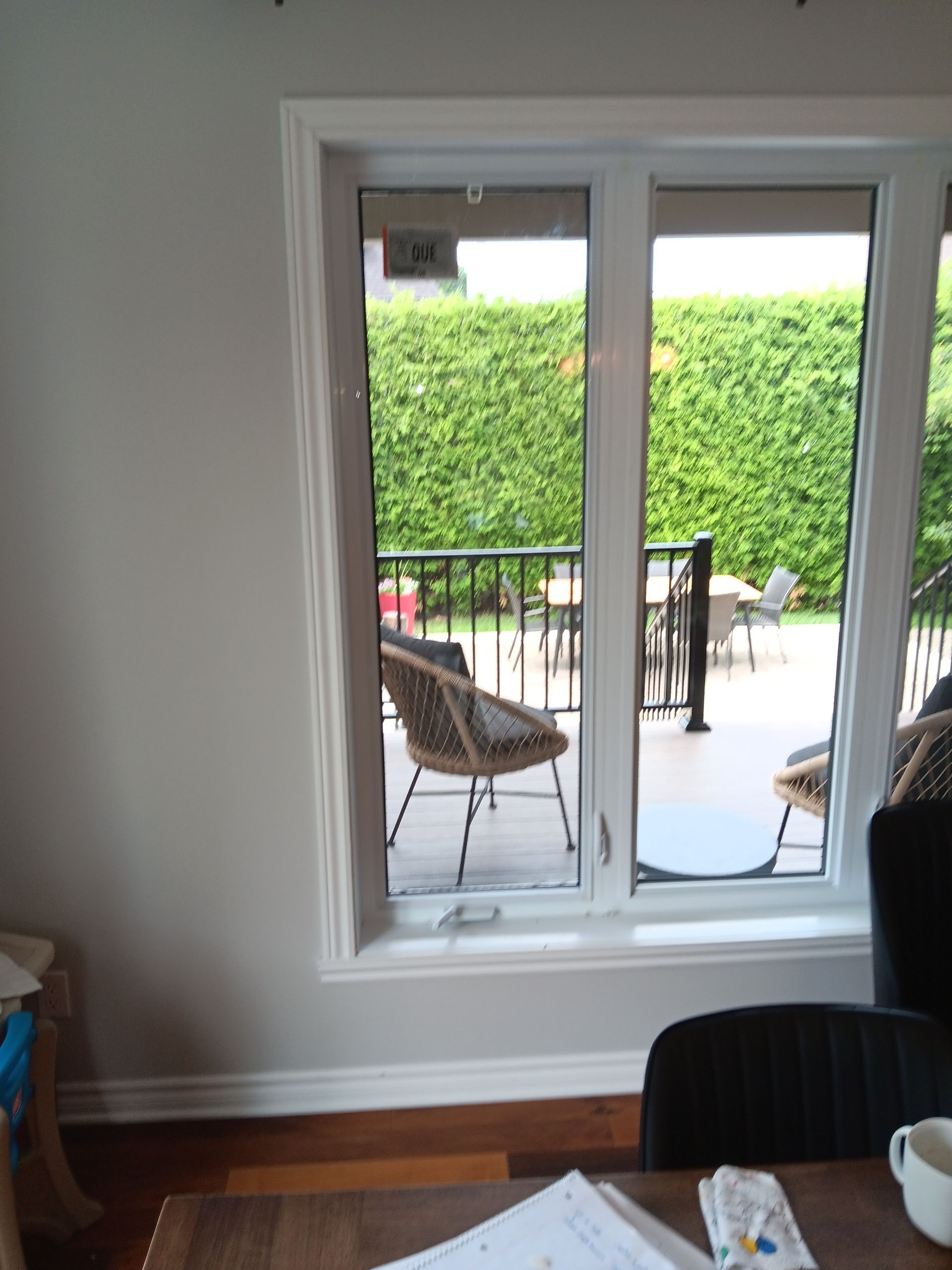 Un séjour avec une table et des chaises et une grande fenêtre avec vue sur un patio.