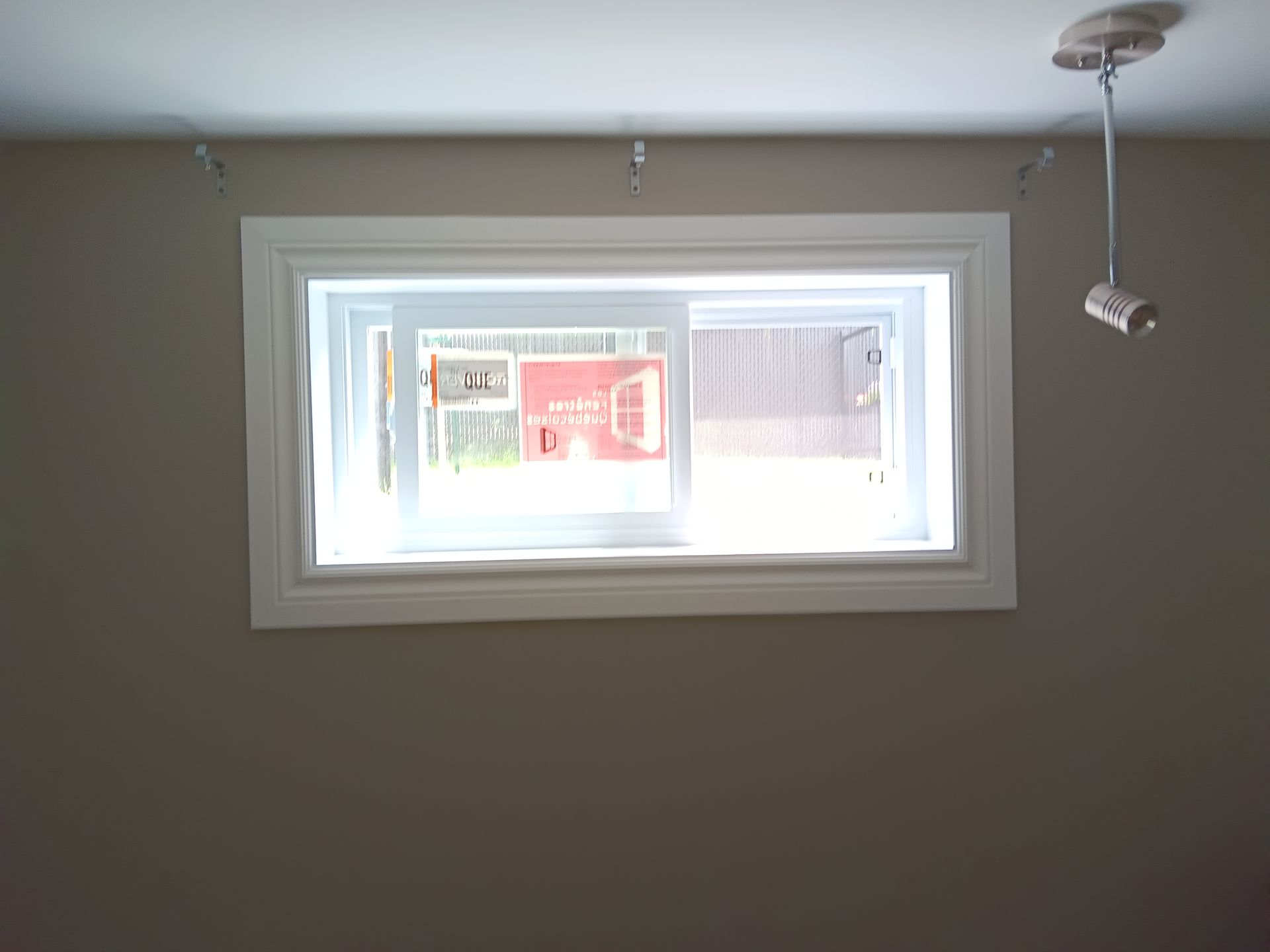 Une fenêtre dans une pièce avec une grange rouge en arrière-plan