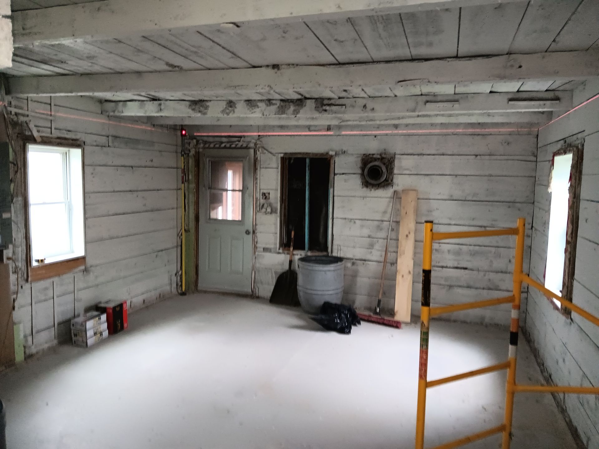 Une pièce vide avec un échafaudage jaune au milieu