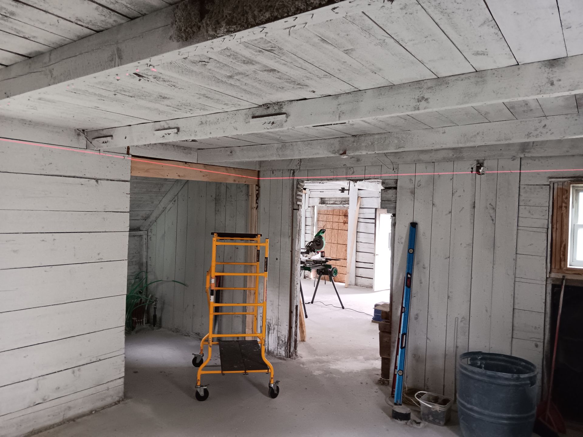 Une pièce avec des murs blancs et une échelle jaune