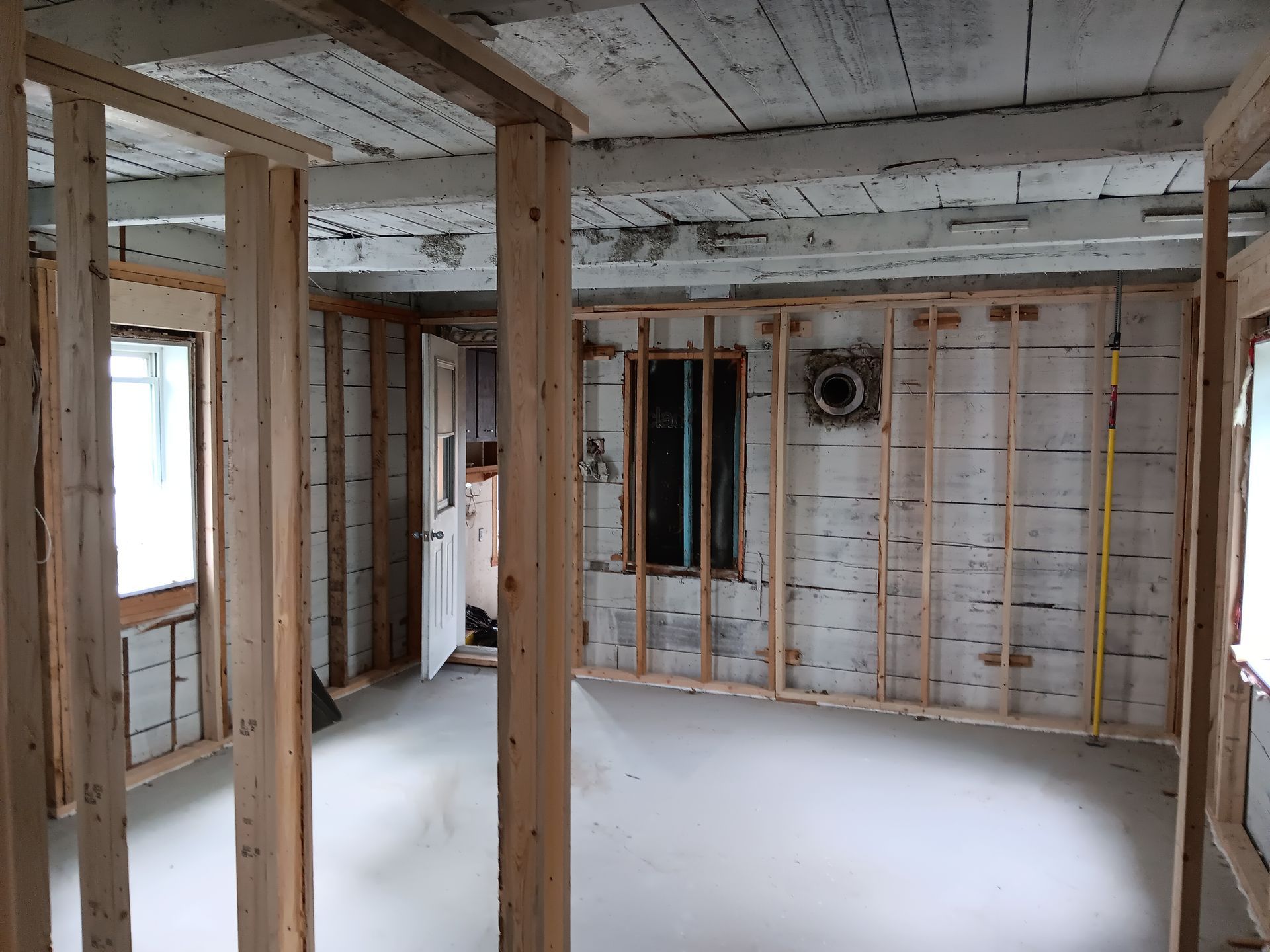 Une pièce avec des murs en bois et un mètre ruban au sol.