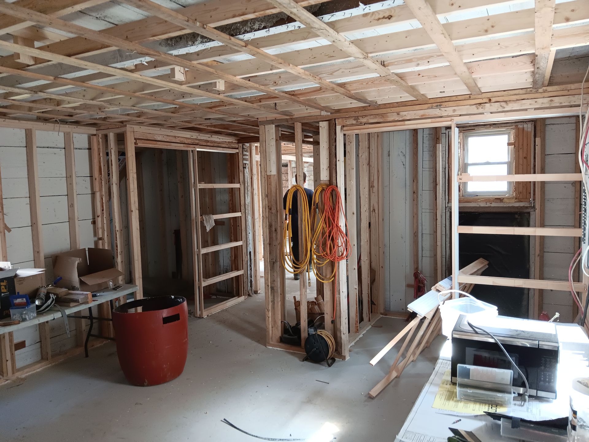 Une pièce en construction avec des poutres en bois et une table.