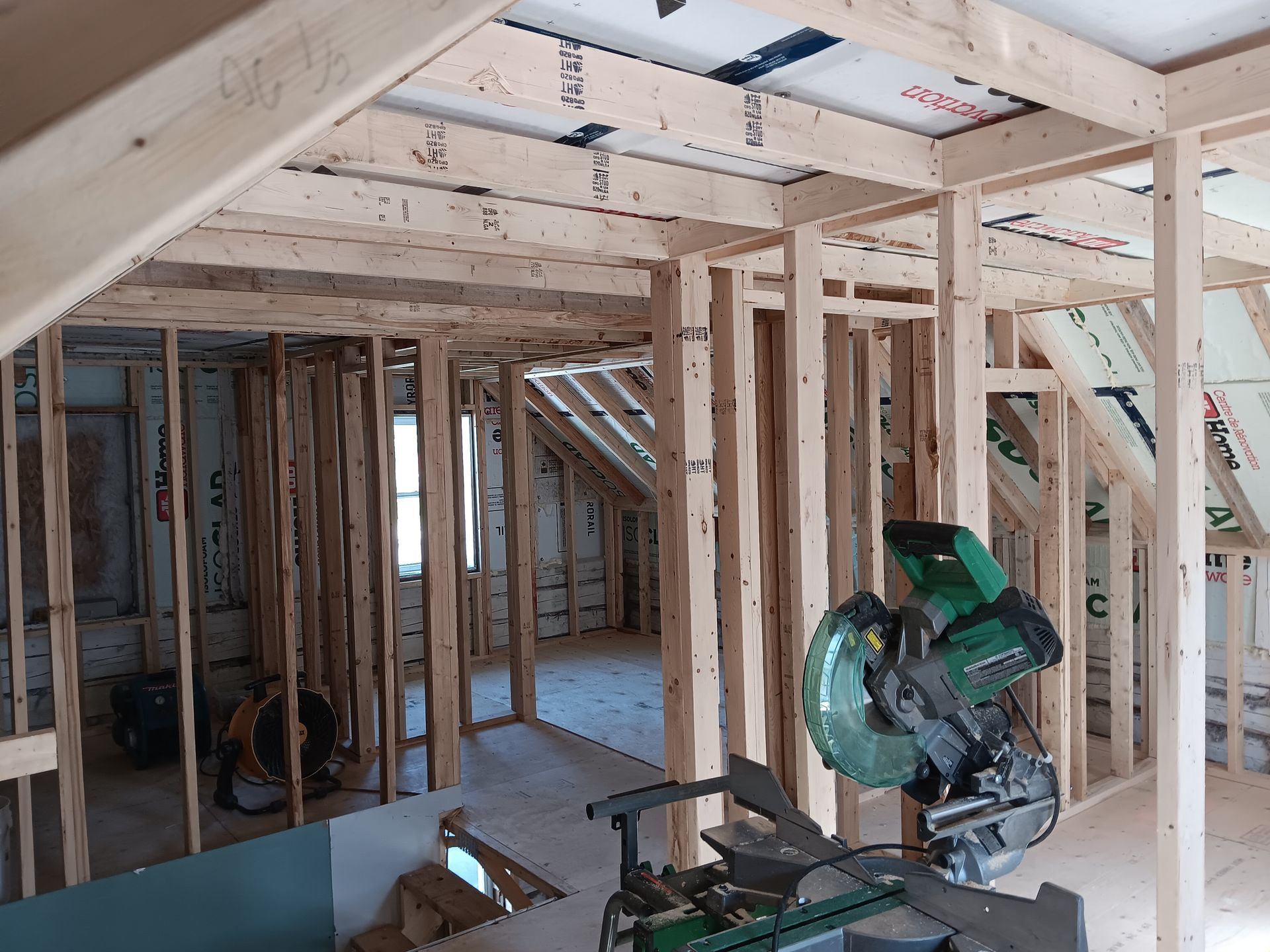 Une scie circulaire est posée au milieu d'une pièce en construction.