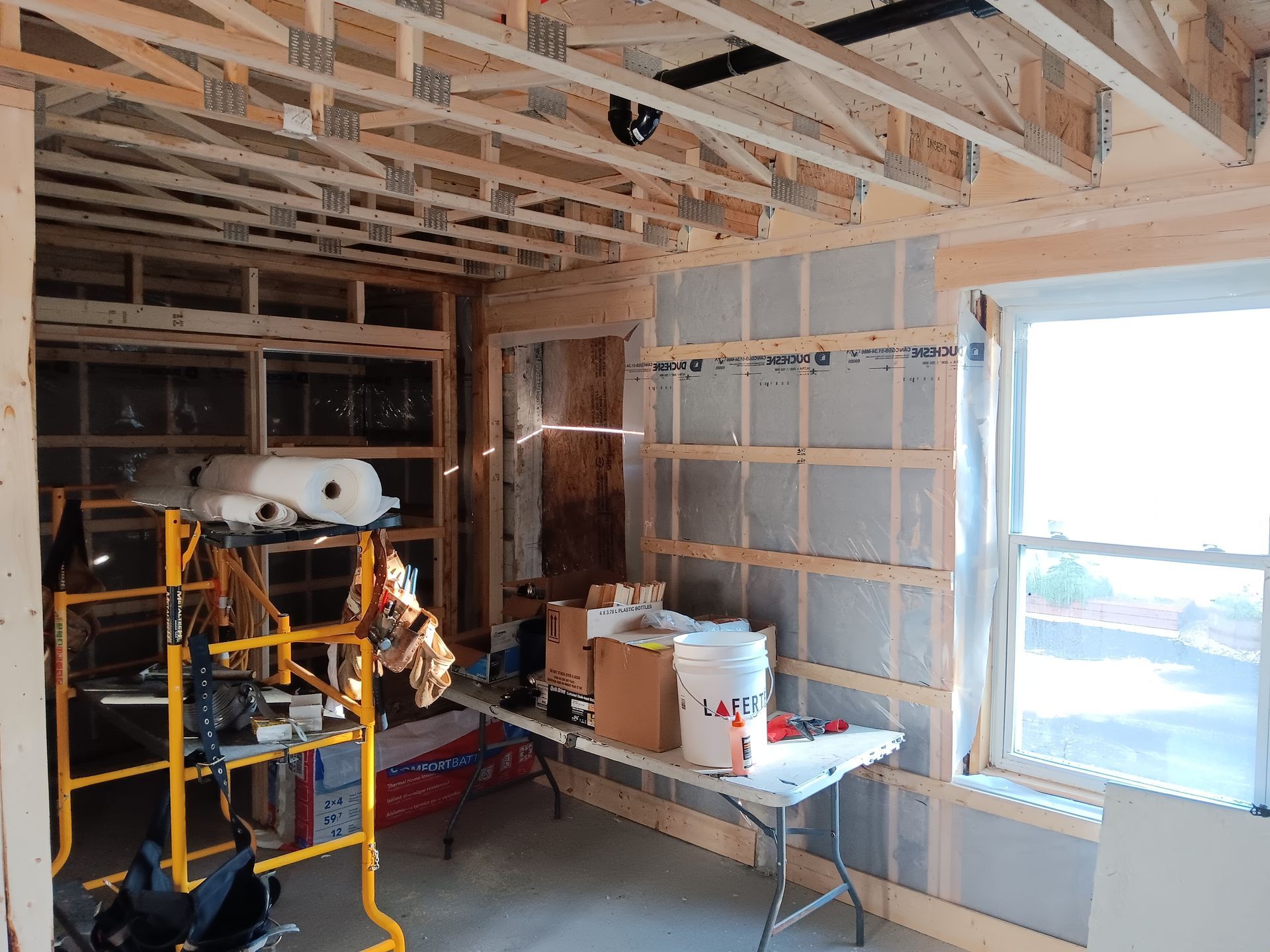 Une pièce en construction avec une table et une fenêtre.