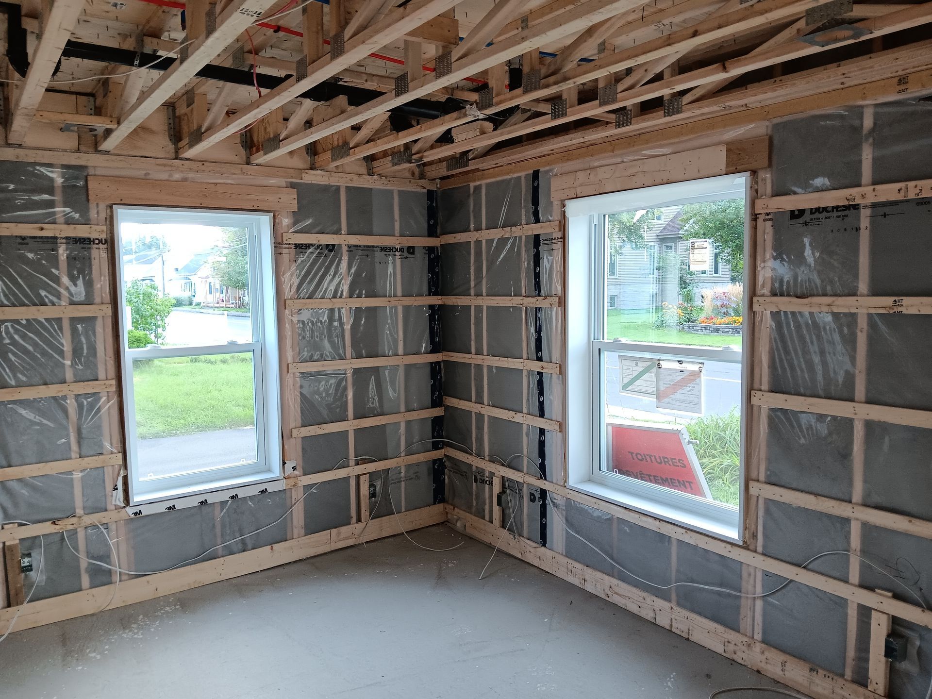 Une pièce dans une maison en construction avec beaucoup de fenêtres.