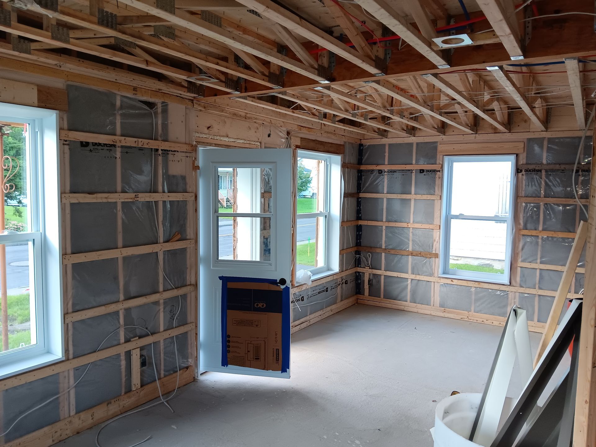Une pièce dans une maison en construction avec une porte et des fenêtres.