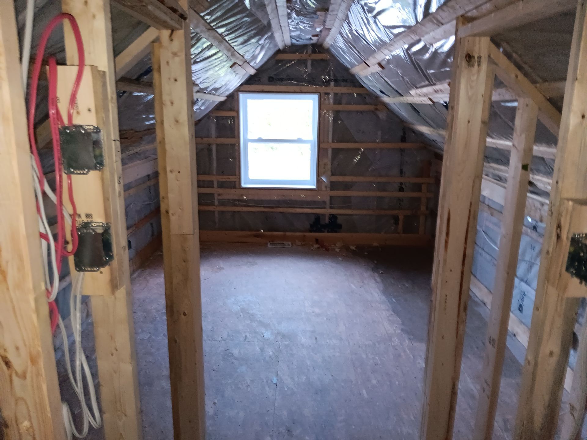 Un grenier avec une fenêtre et beaucoup de fils