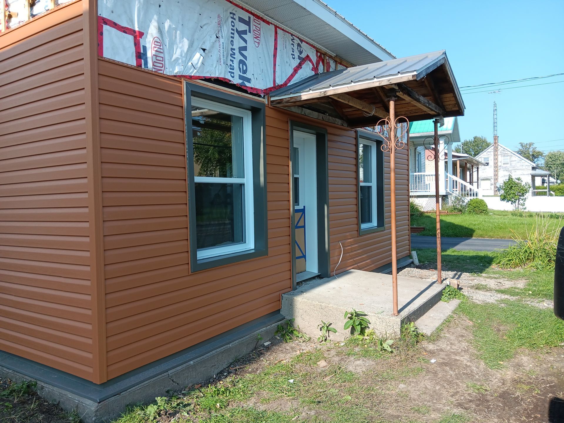 Une maison avec un porche et un toit est en construction.