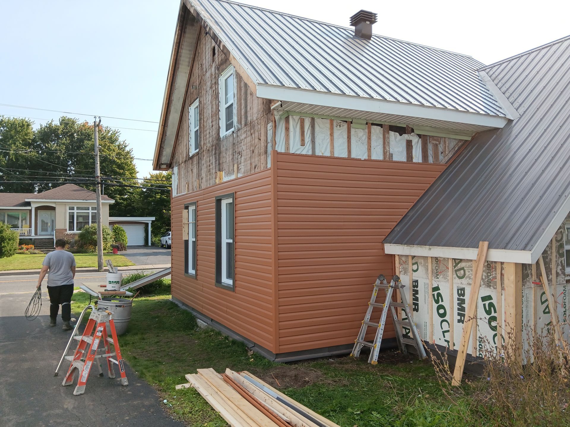 Un homme se tient devant une maison en cours de rénovation