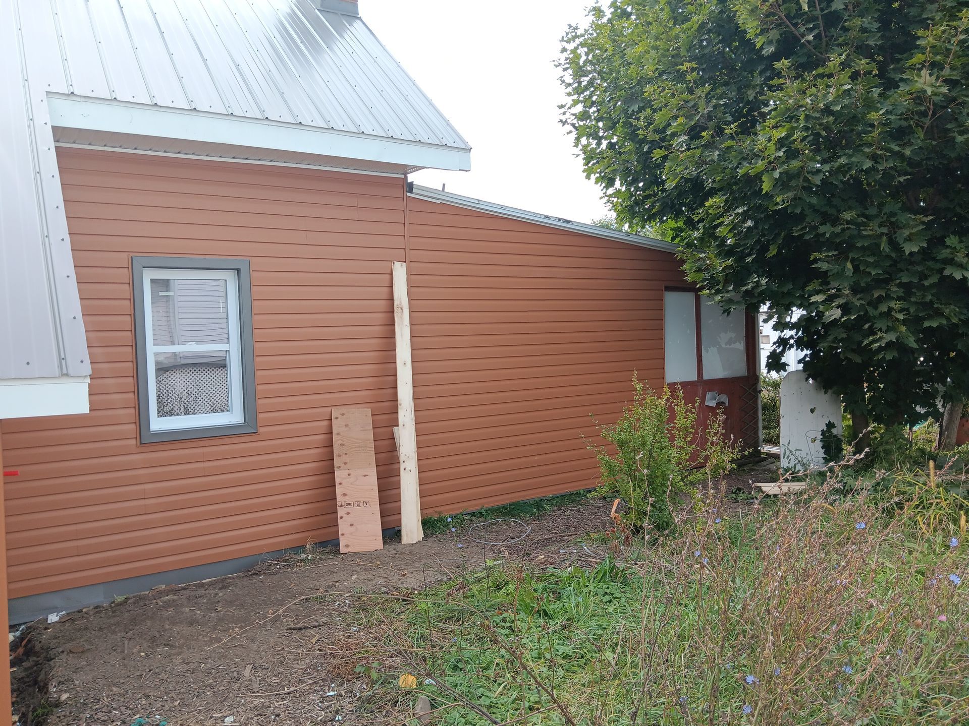 Une maison marron avec un toit blanc et une fenêtre