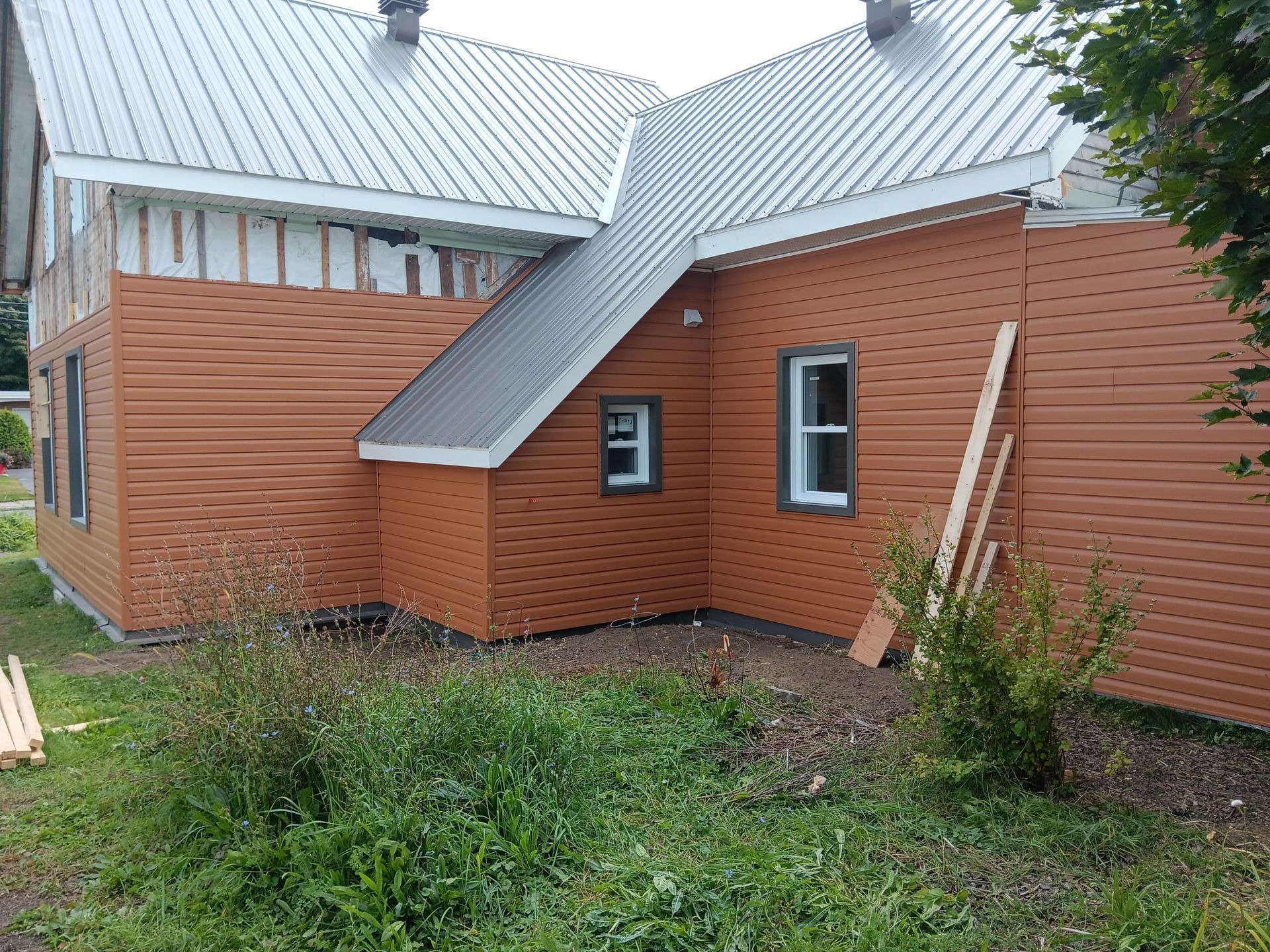 Une maison en brique avec un toit en métal est en construction
