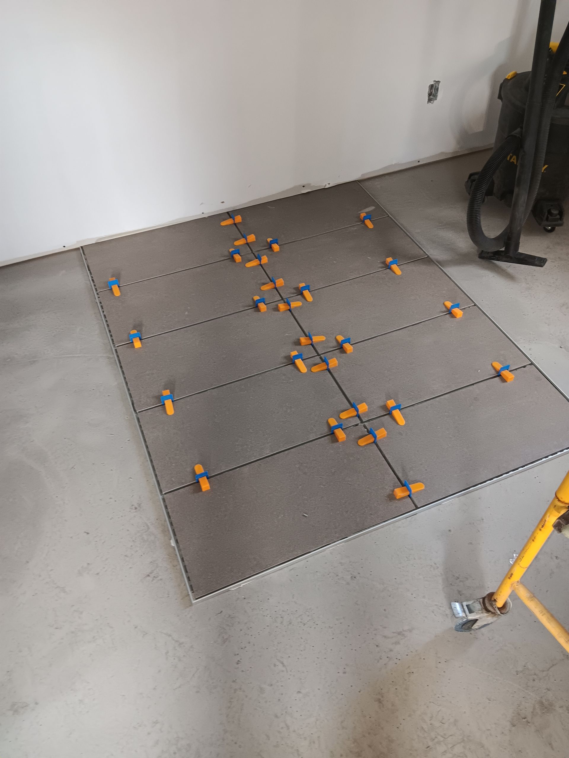 Un sol carrelé est en cours d'installation dans une pièce.