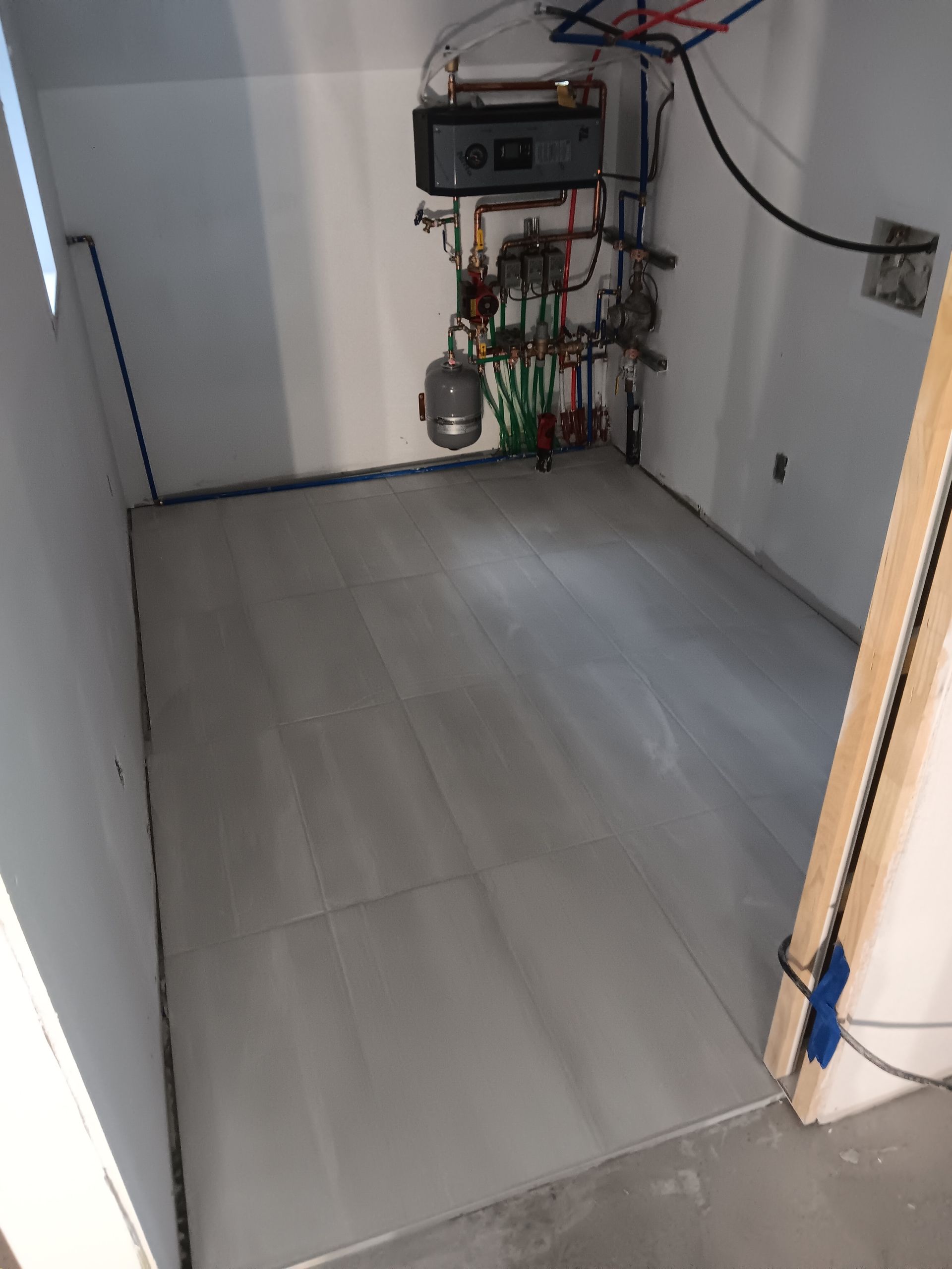 Une pièce avec beaucoup de tuyaux et de fils au sol