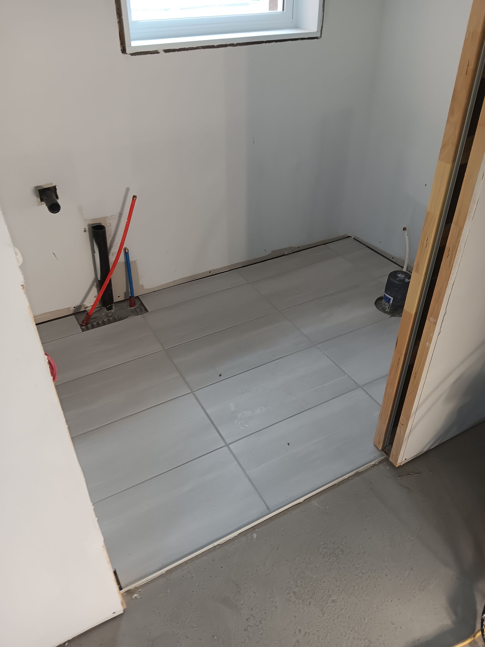 Une pièce avec du carrelage au sol et une fenêtre.