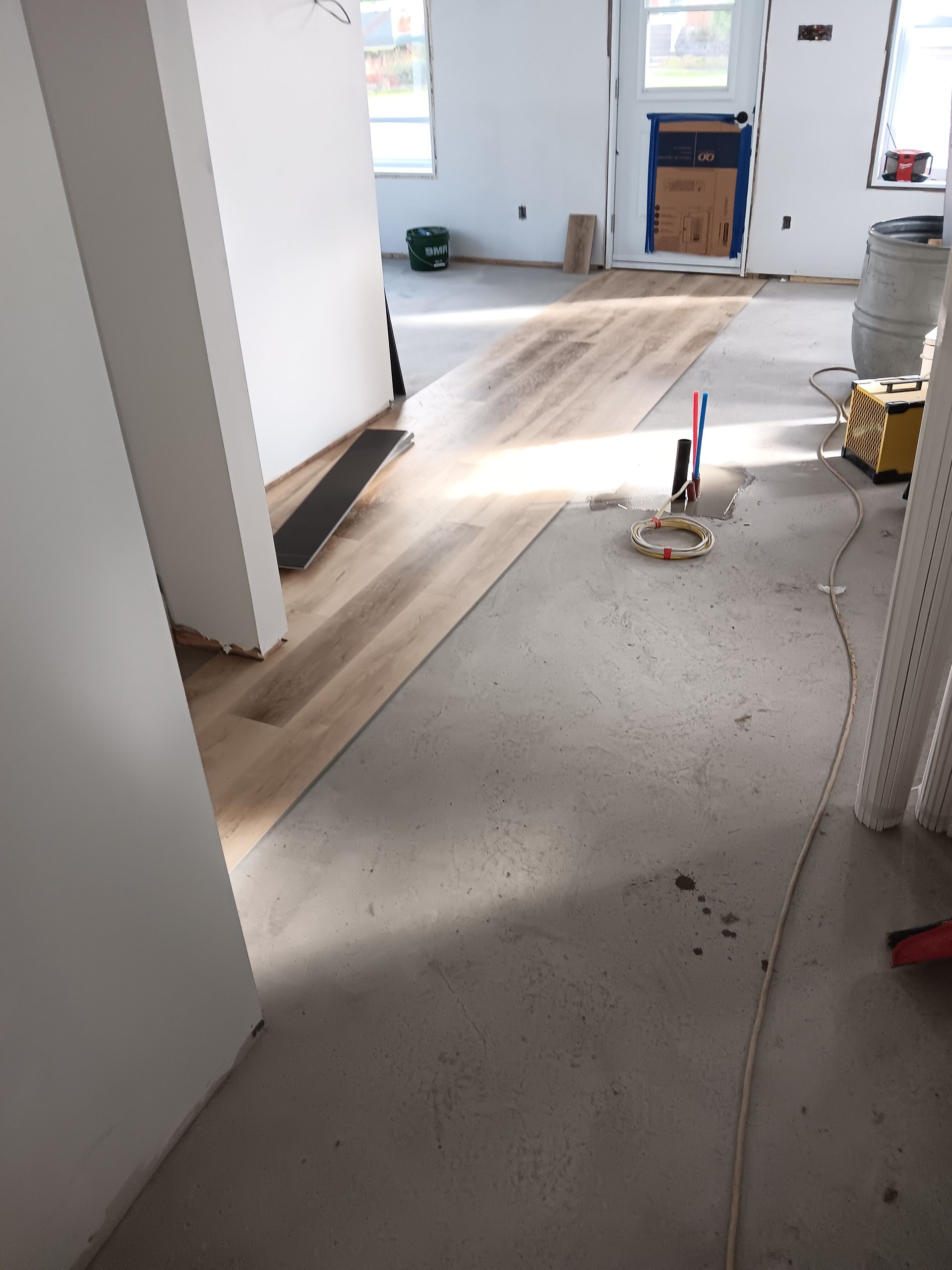 Une pièce avec du parquet et des murs blancs