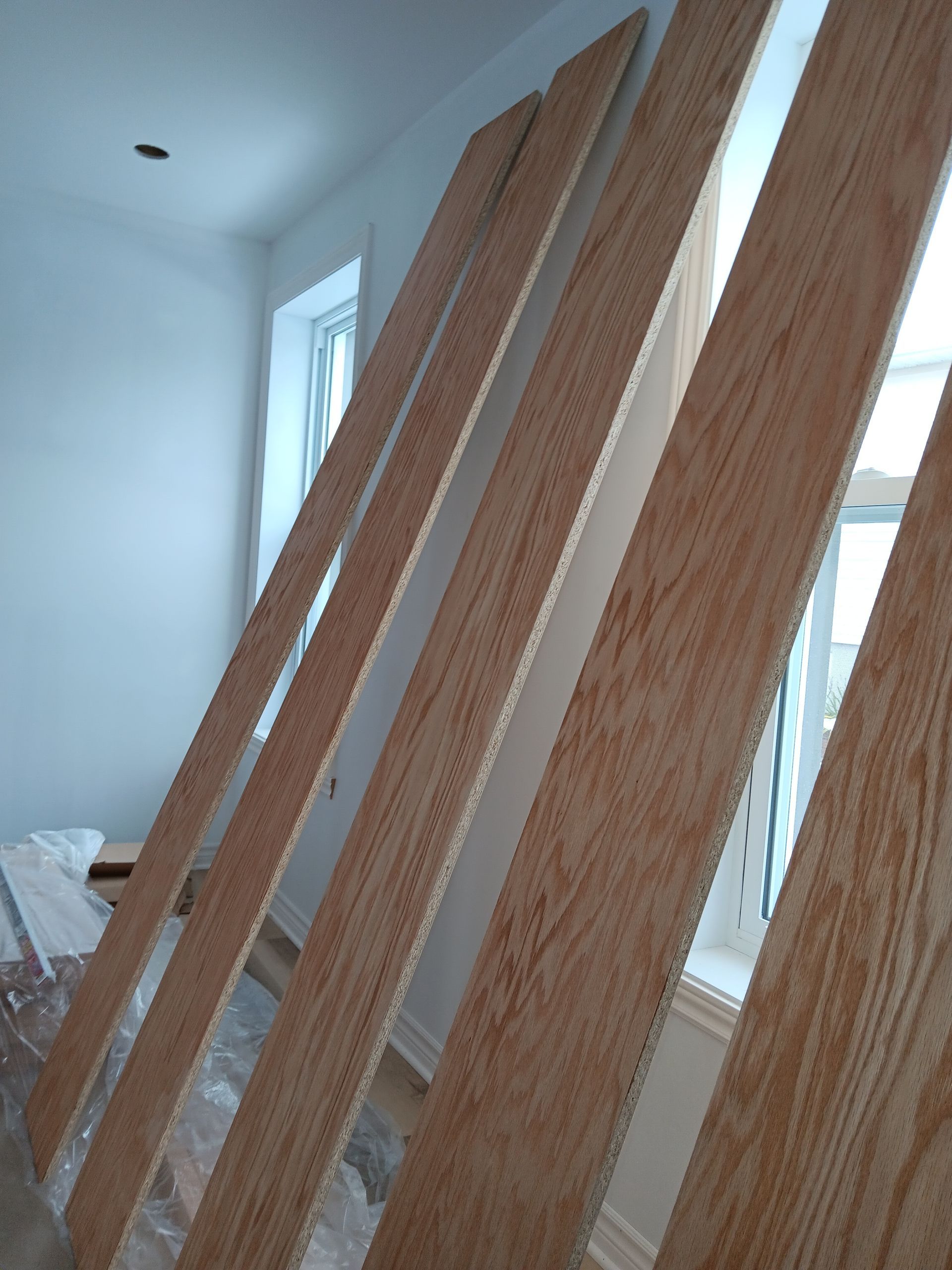 Un tas de planches de bois sont empilées les unes sur les autres dans une pièce.