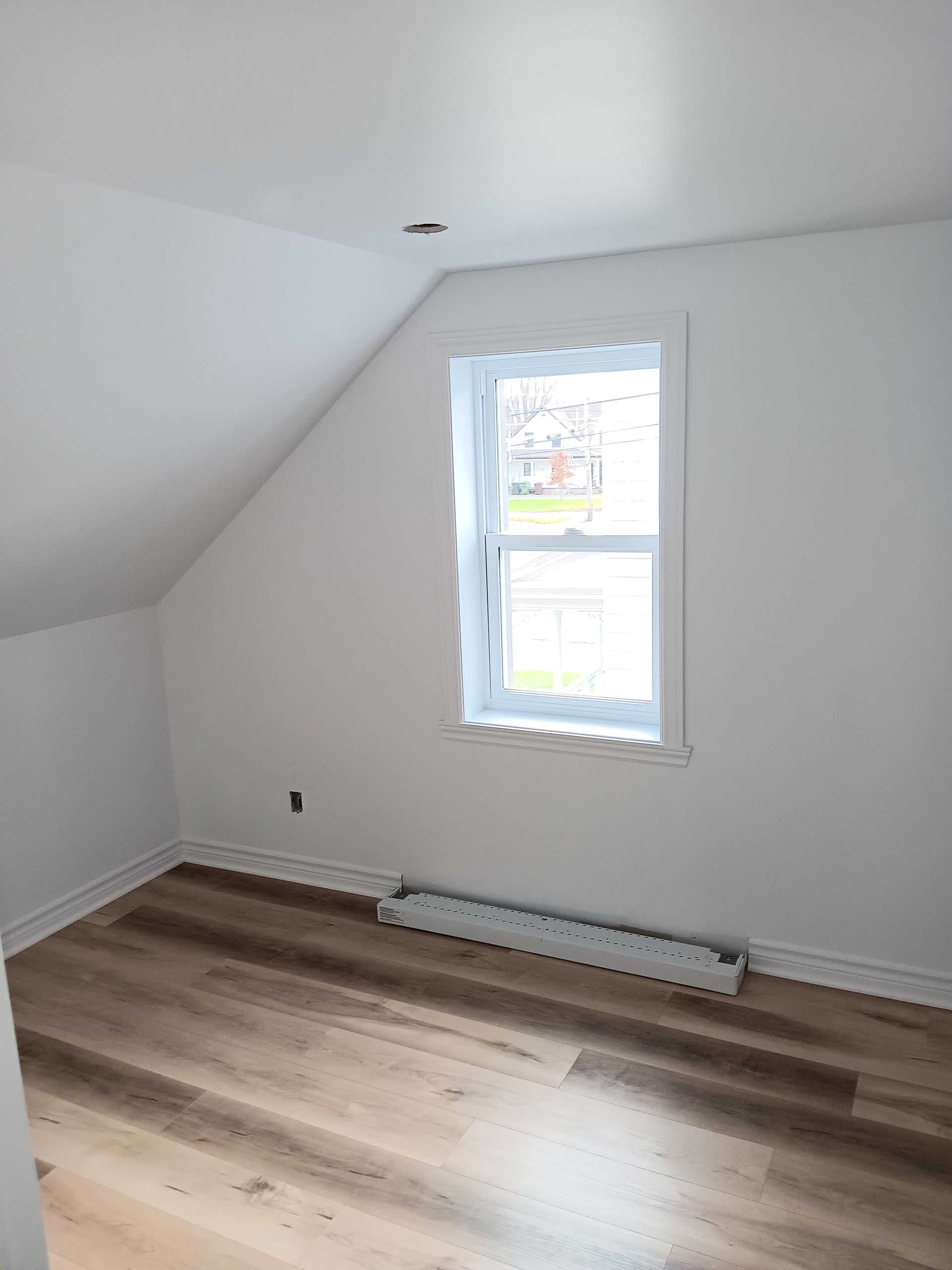 Il y a une fenêtre dans le coin de la pièce.