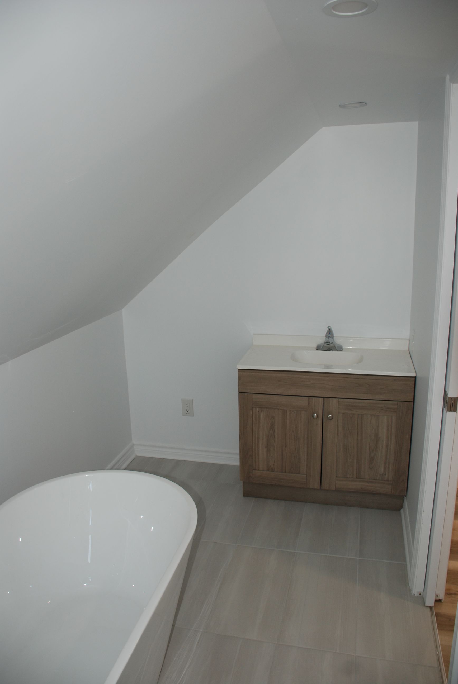 Une salle de bain avec baignoire , lavabo et armoires.