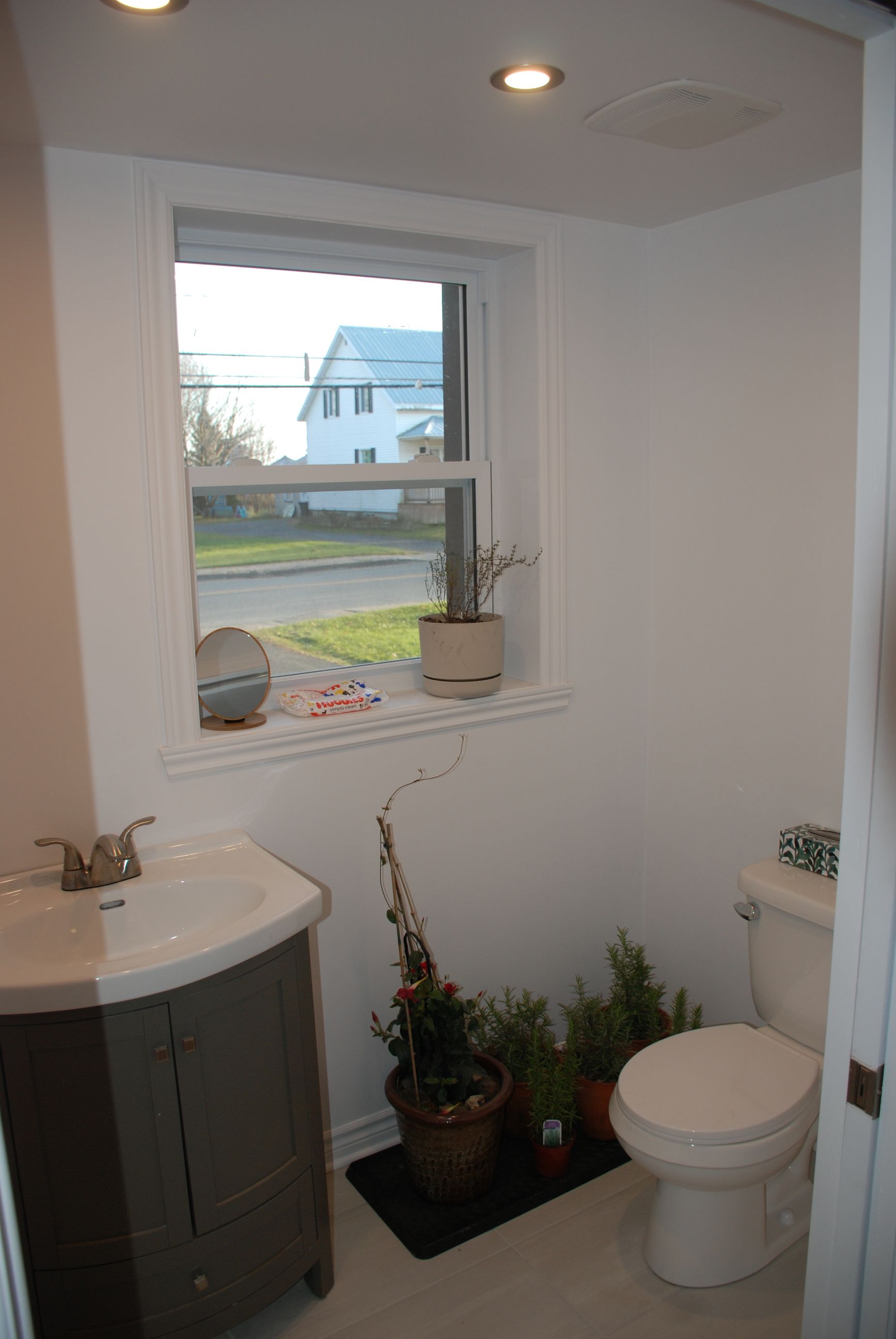 Une salle de bain avec lavabo , toilettes et fenêtre.